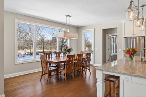 The adjoining dining area features a statement light fixture and unobstructed views of the serene backyard. The layout was thoughtfully planned to accommodate a future deck and porch expansion, further enhancing indoor-outdoor living.