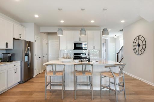 The Ashton's kitchen features a huge island surrounded by even more quartz counters. Durable and beautiful is a great combo! Photo of model home.