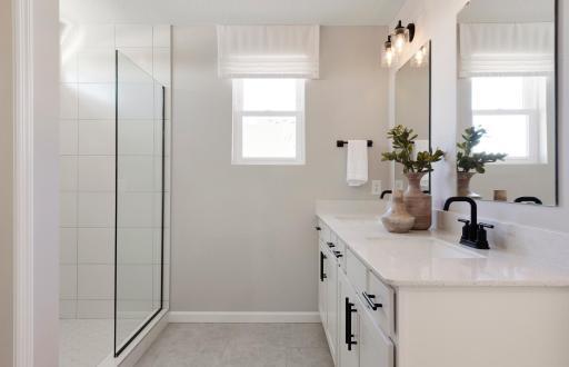 Perfectly located off the bedroom is the Primary Bathroom. This bathroom features modern finishings such as white cabinetry with quartz countertops mixed with the comfort of your double sink vanity and roomy shower. Photo of model home.