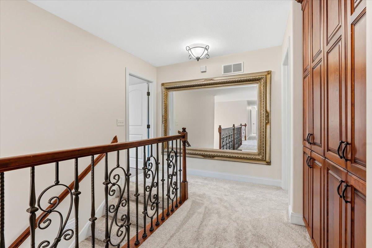 Stairway to upstairs with custom cabinetry along the hallway