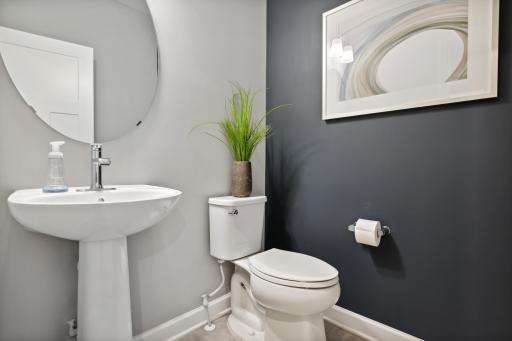 (Photo of a decorated model, actual finishes will vary.) A first-floor powder room is easily accessible from the communal living and dining spaces.