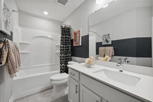 (Photo of a decorated model, actual finishes will vary.) This full second-floor bathroom features a wide single vanity and shower-tub combination.