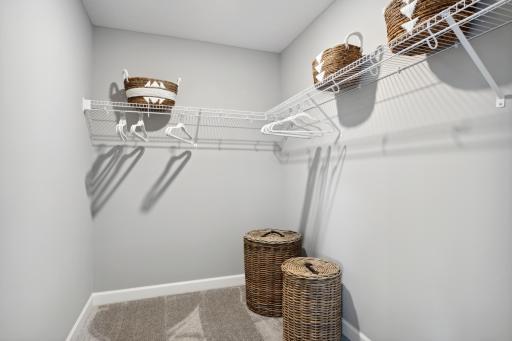 (Photo of a decorated model, actual finishes will vary.) Ventilated shelving is featured in the walk-in closet.