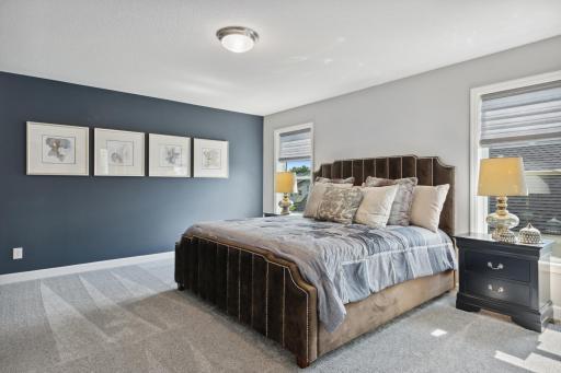 (Photo of a decorated model, actual finishes will vary.) The owner’s suite is located on the home’s second level, complemented by a spa-like bathroom and walk-in closet.