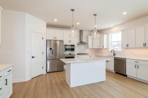 (Photo of a decorated model, actual finishes will vary.) This stylish and multifunctional kitchen comes complete with brand-new stainless steel appliances, sleek quartz countertops and Shaker-style cabinetry.