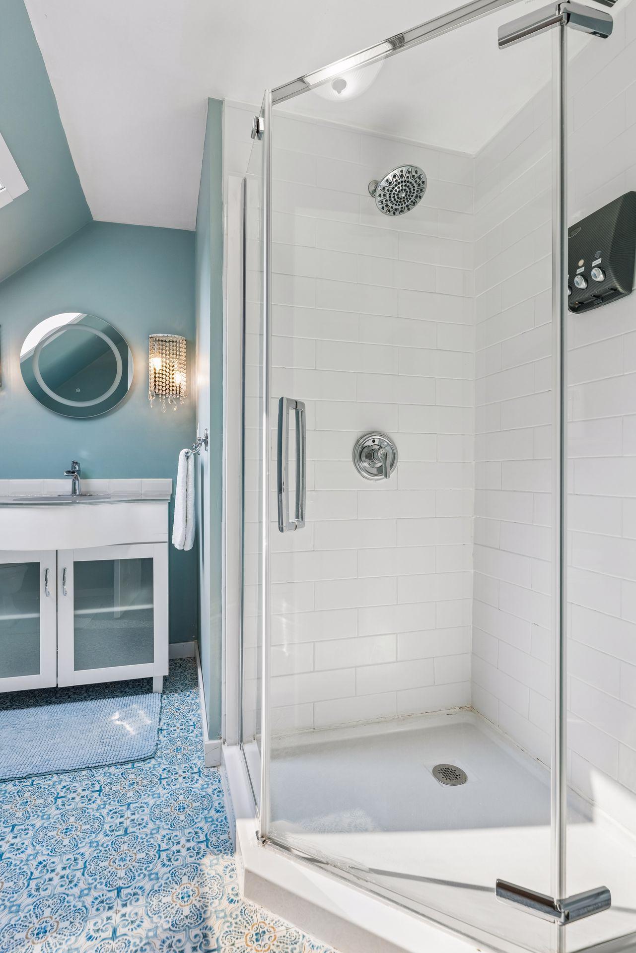 Step-in shower with tile surround and glass doors.