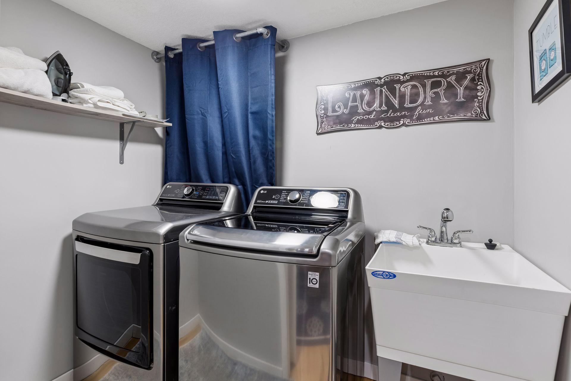 Lower level laundry room/closet, with utility sink and open shelving.