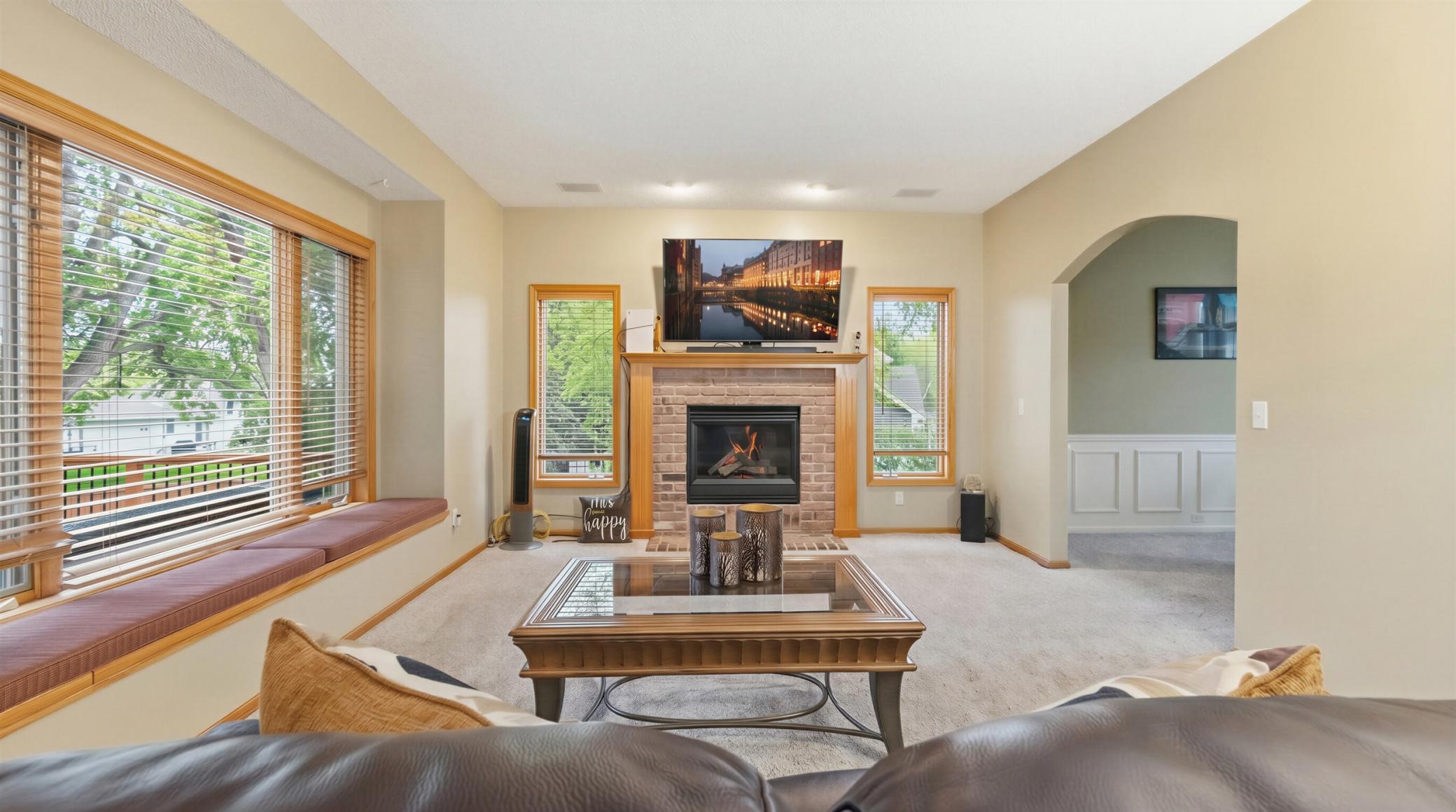 Formal family room in the main level with lots of windows and a gas fireplace for cozy nighs.