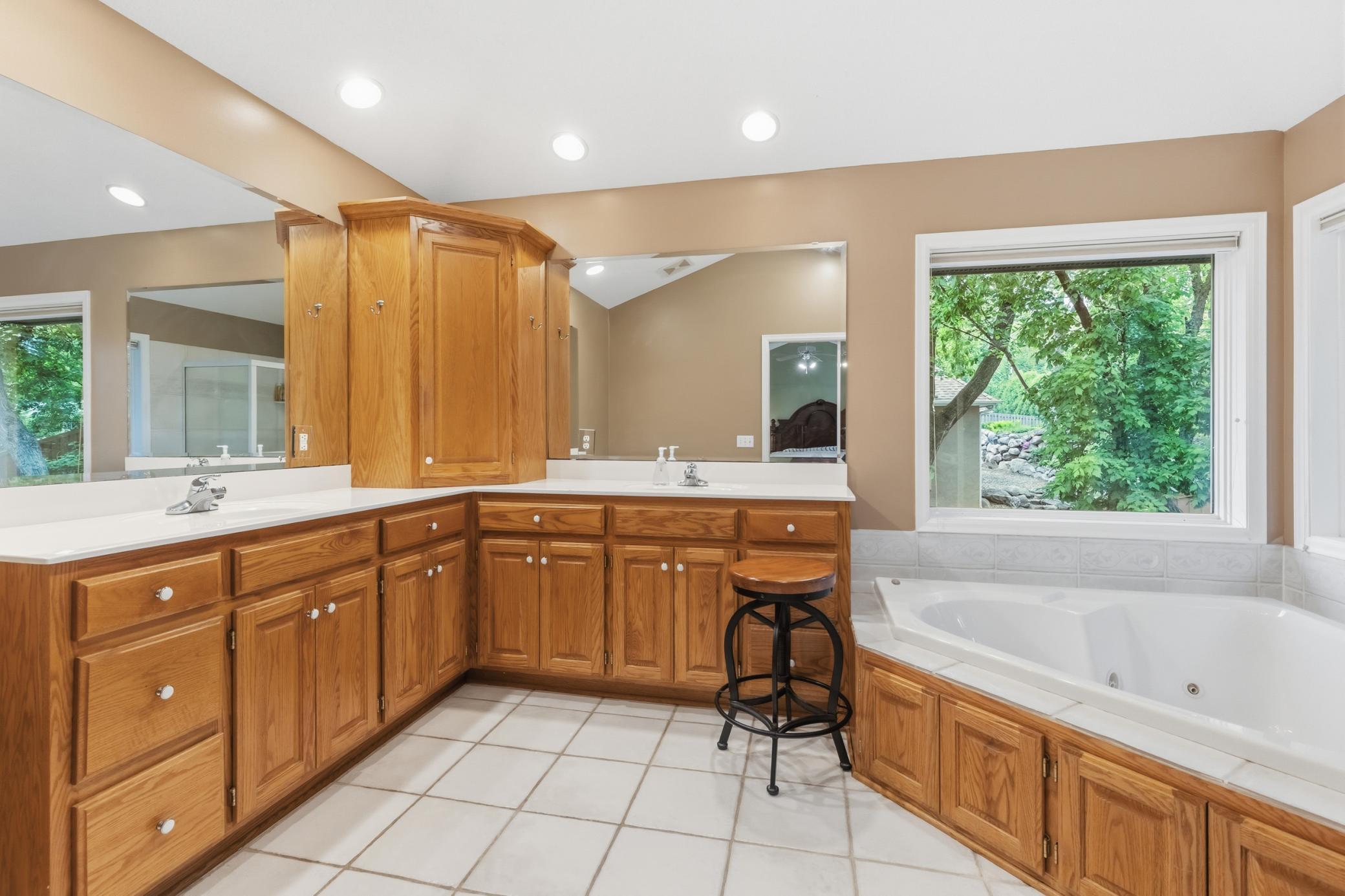 The primary bathroom has dual vanity sinks and a separate soaking/jetted tub and shower.