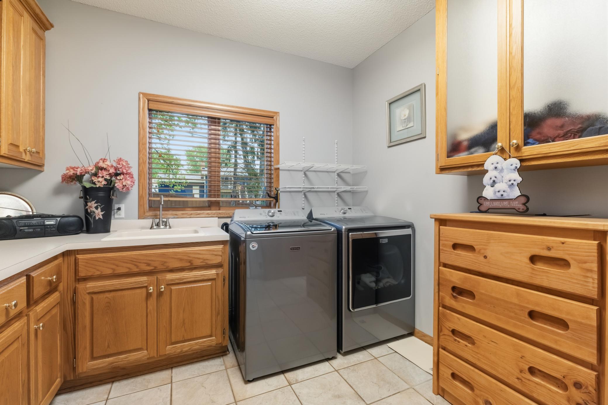 The laundry in the main level has a window and sink. Lots of storage in the room. There's also the well-placed laundry chute