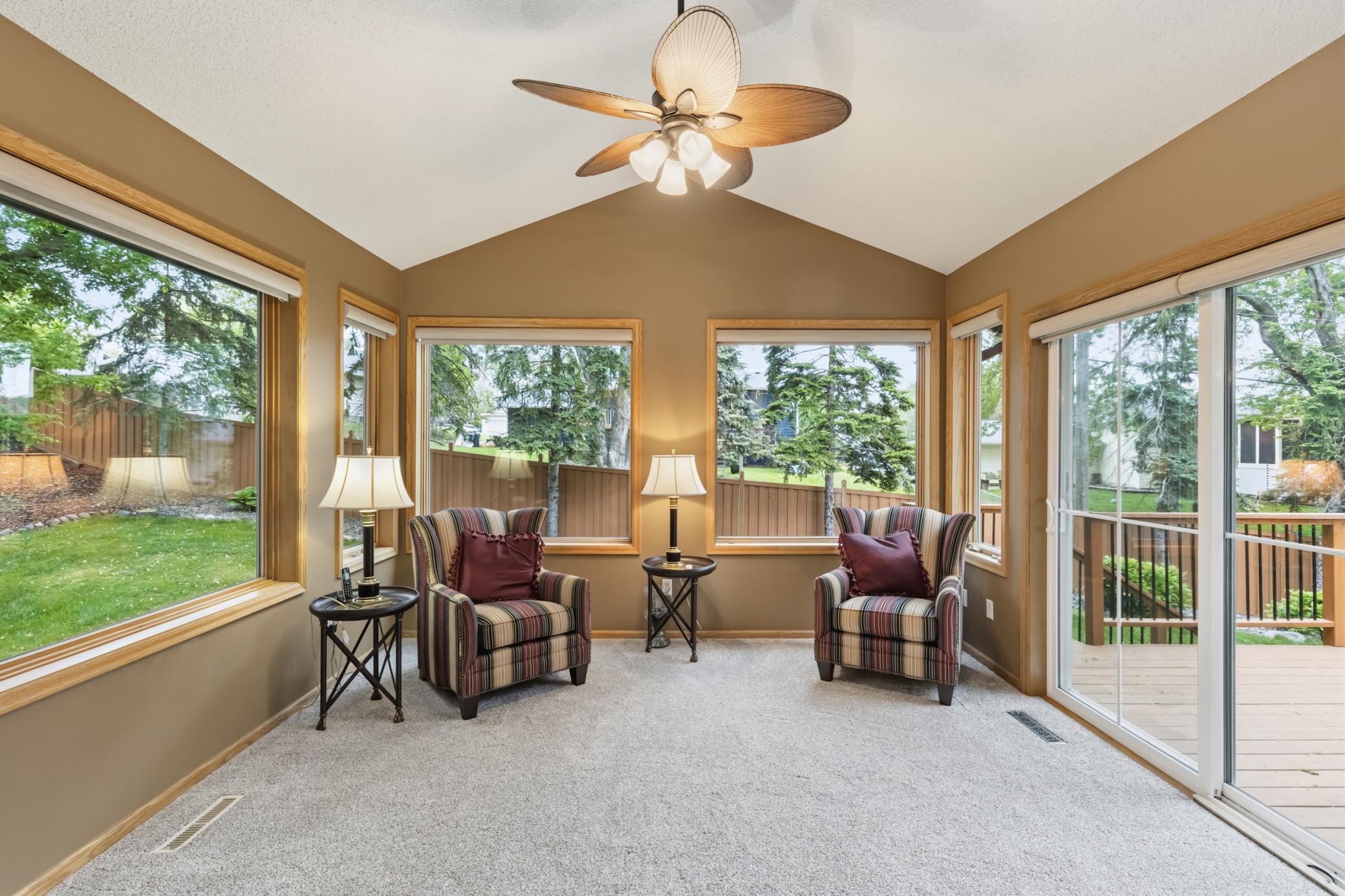 Stunning four-season sunroom with windows throughout that leads to the deck.