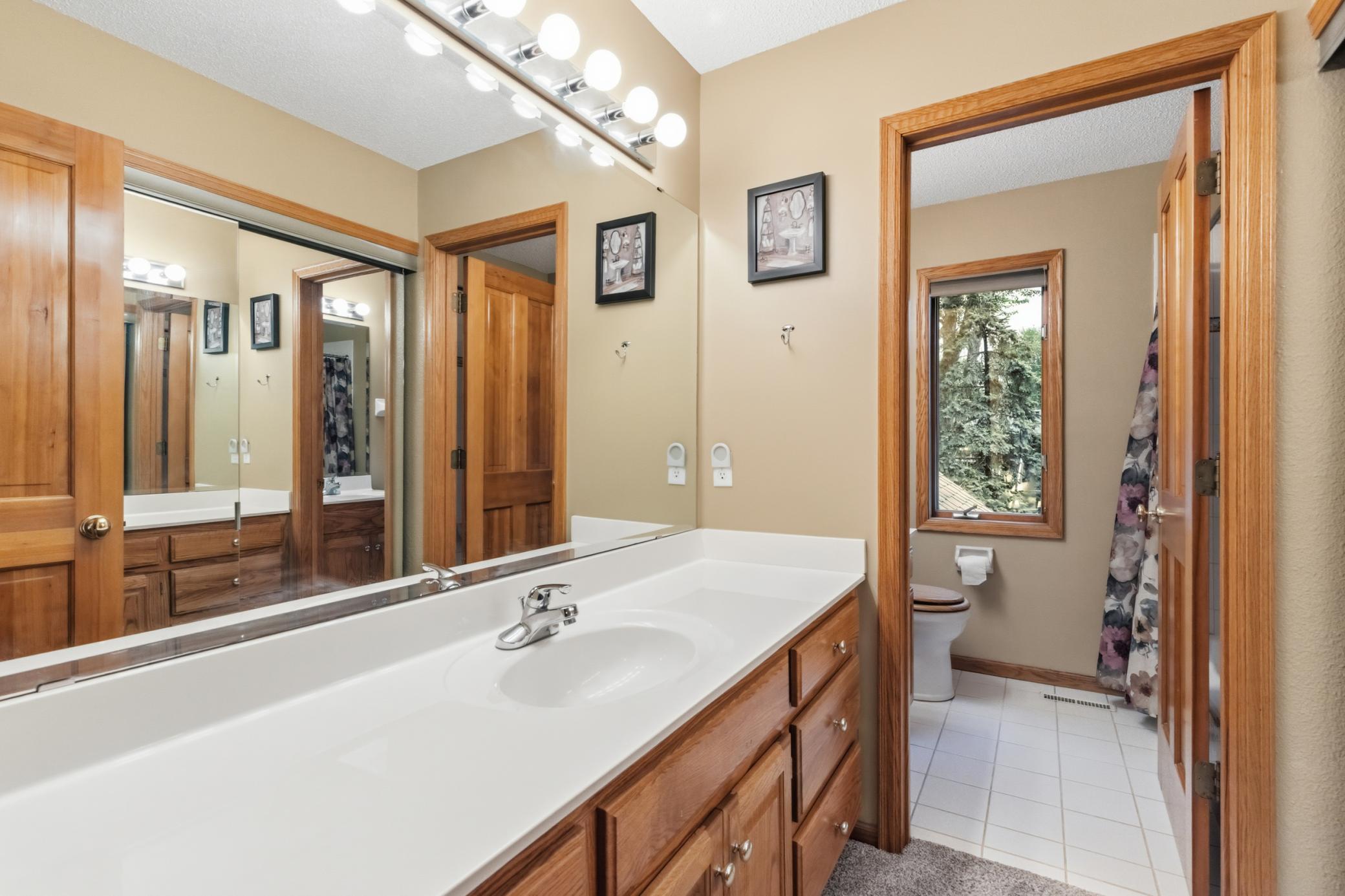 The upper-level full bathroom. The tub/shower and toilet is in a separate room with a window.
