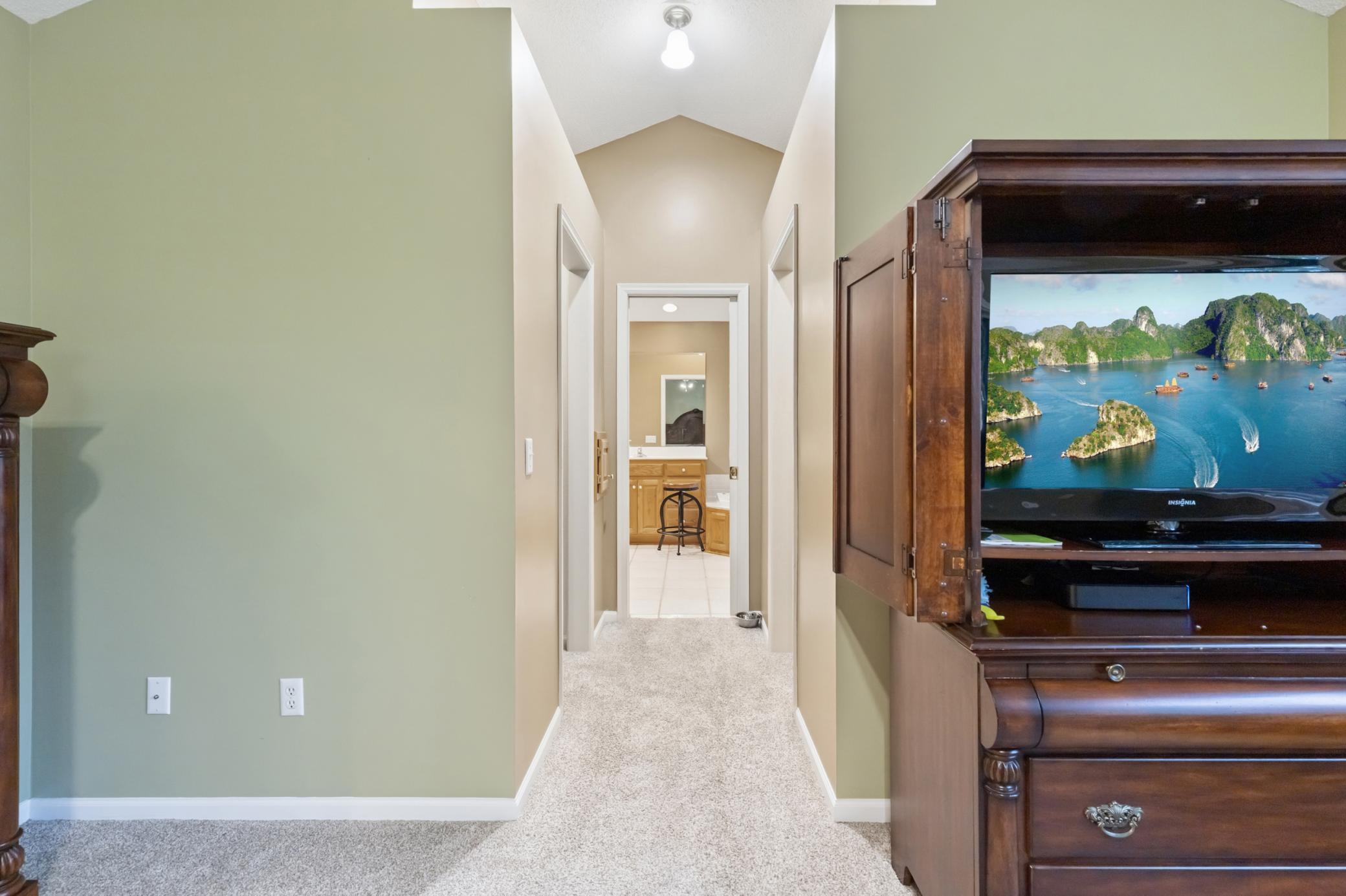The primary bedroom has two walk-in closets leading to the ensuite bath. There's a laundry chute on the left side of the hallway going to the primary bath.
