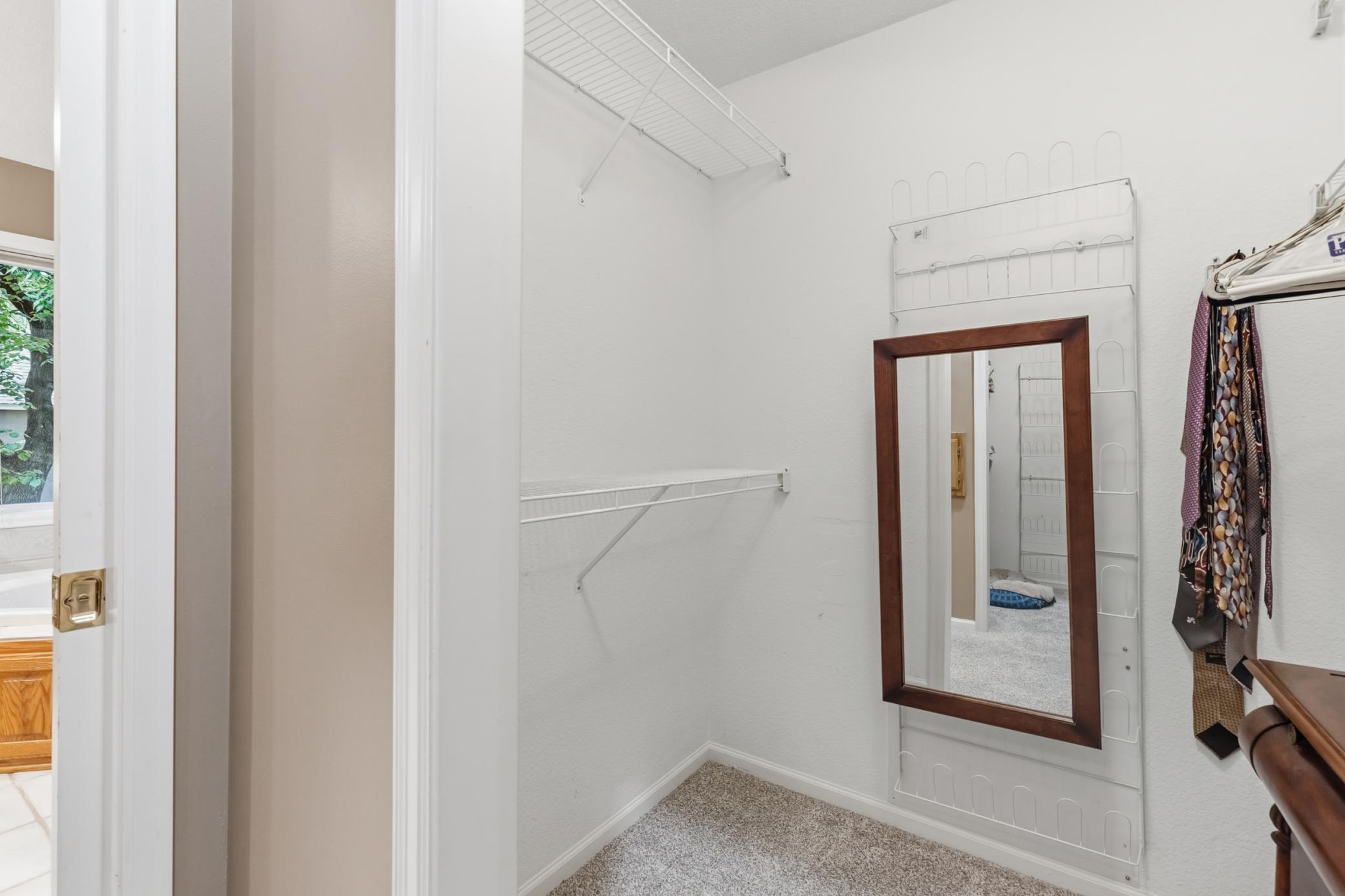 A partial view of one of the walk-in closets in the primary bedroom.