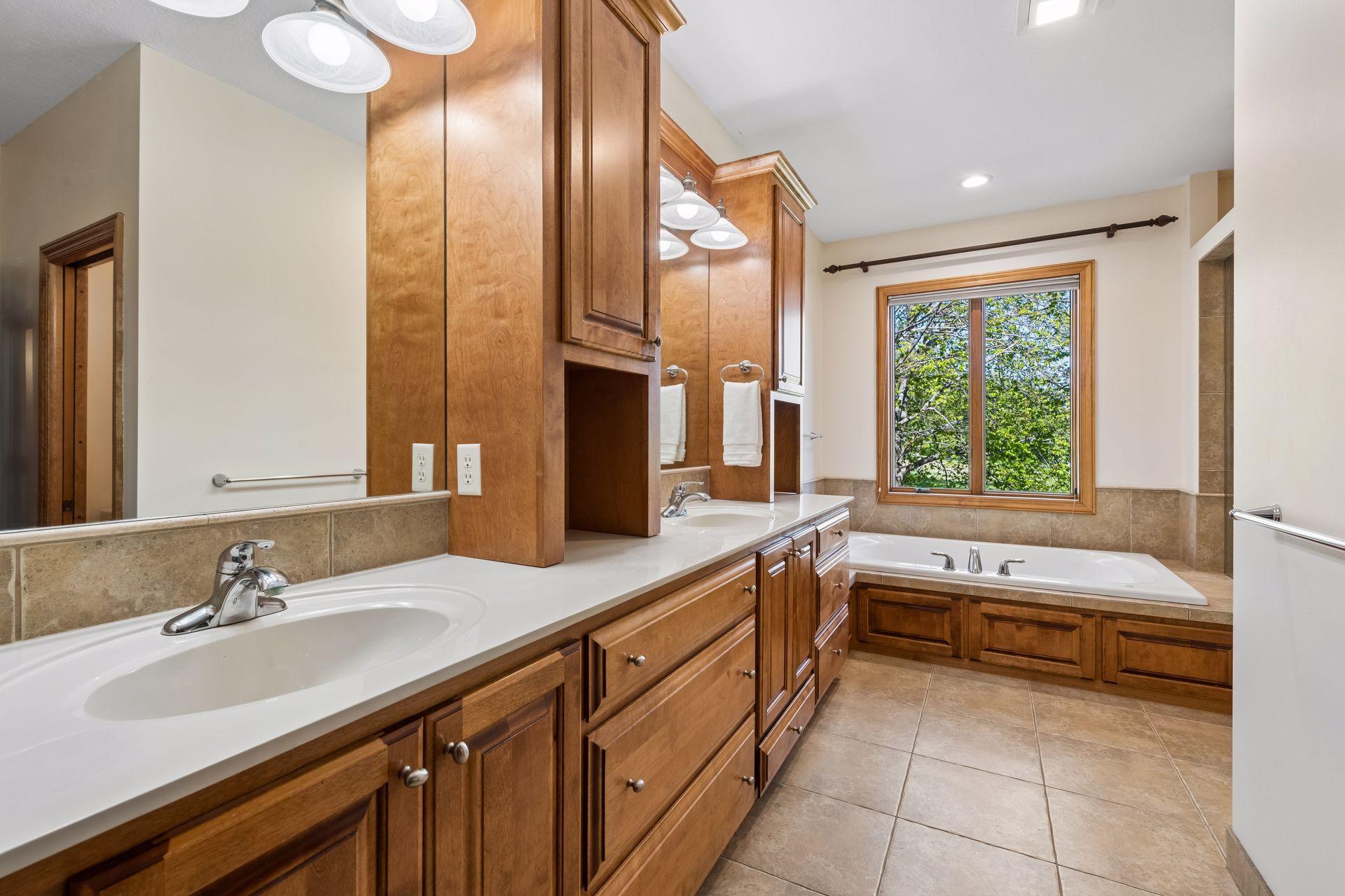 Private, primary bathroom with two sinks, separate tub & shower