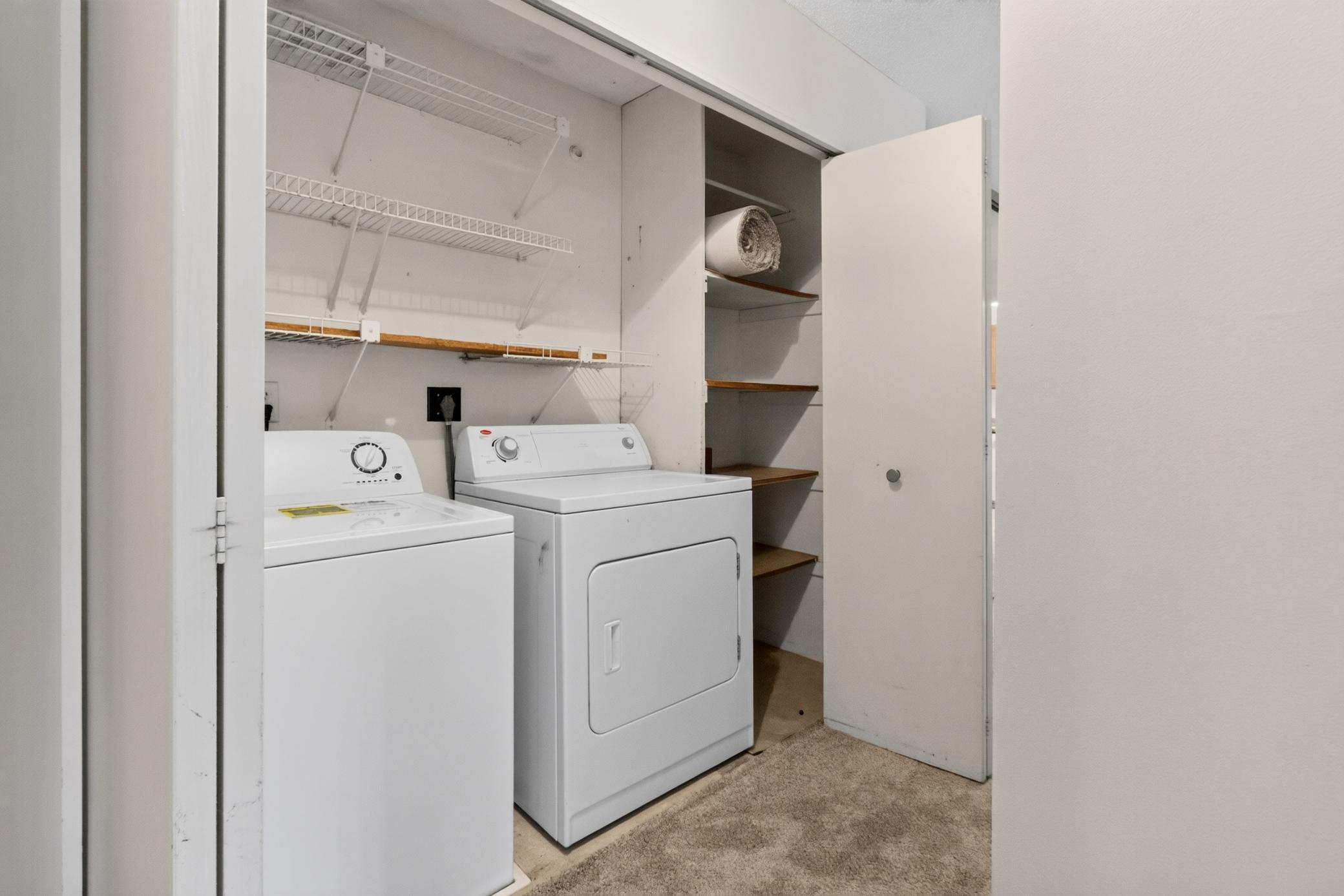 In-unit laundry closet comes complete with a full-size washer and dryer, plus built-in wire shelving for effortless organization