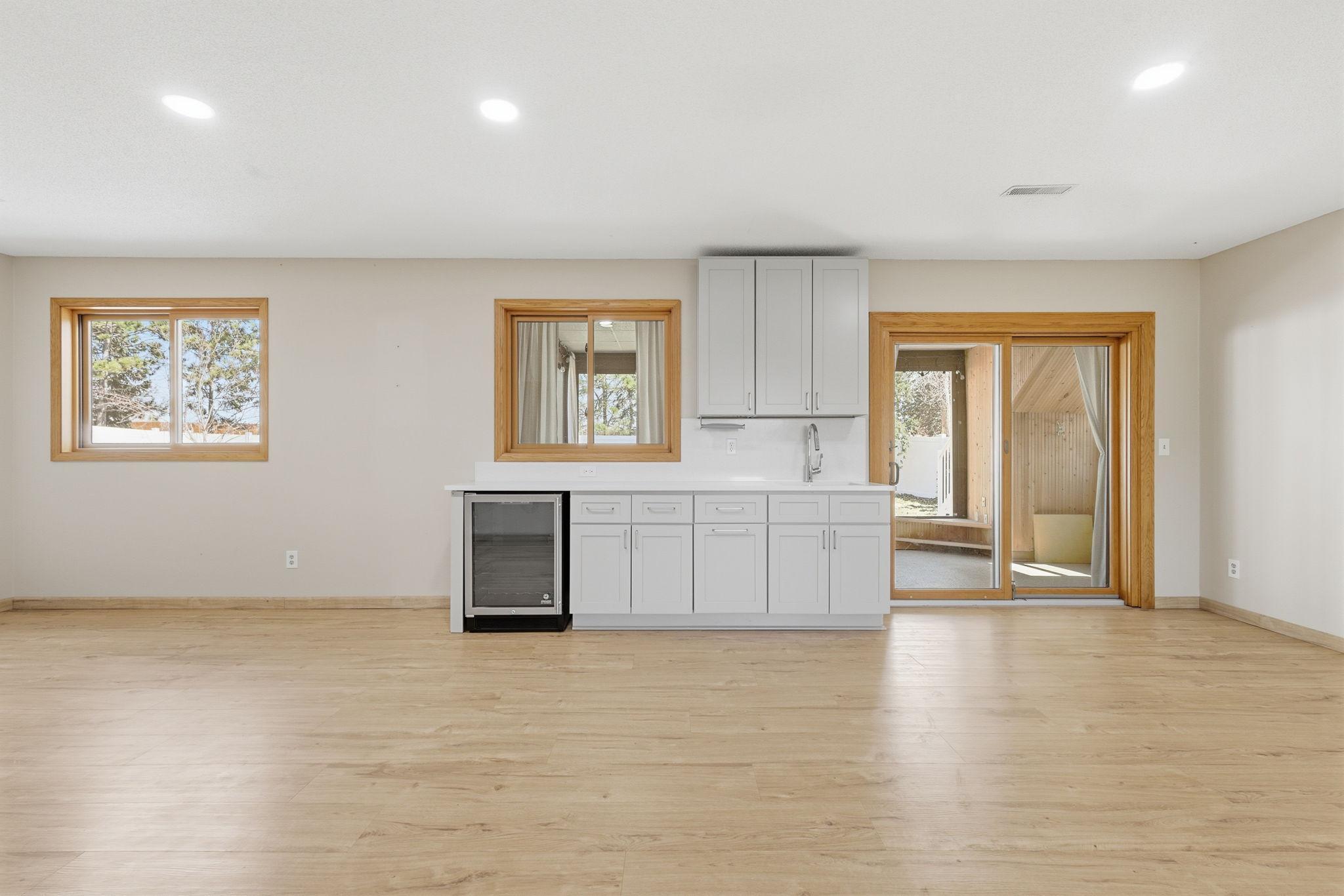 Wet bar area with wine fridge and storage