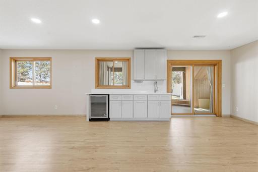 Wet bar area with wine fridge and storage