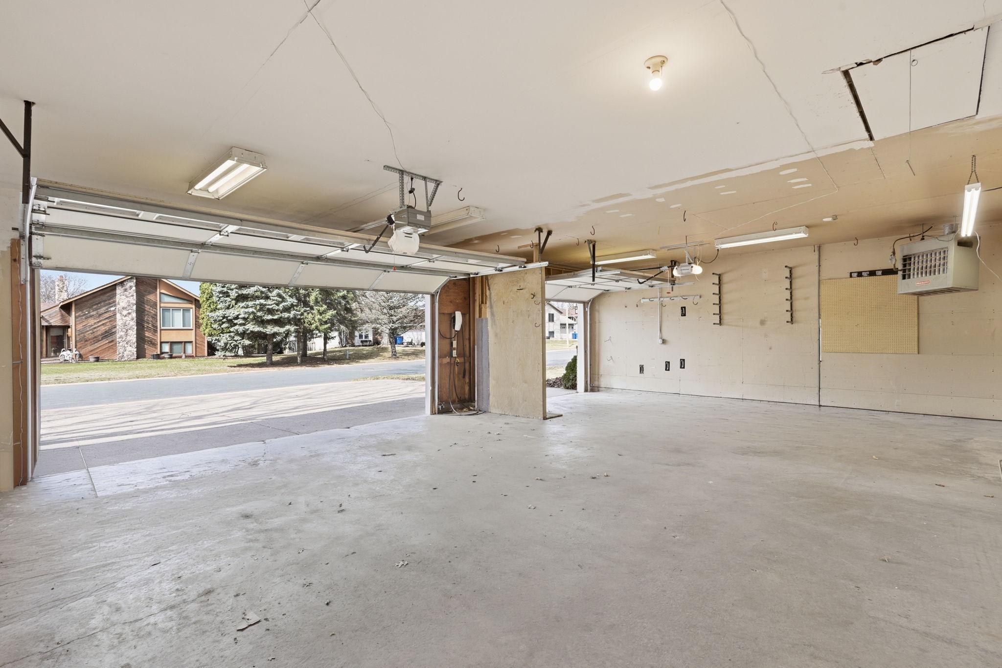 Clean, three-stall garage with ample storage space for vehicles, outdoor equipment and toys!