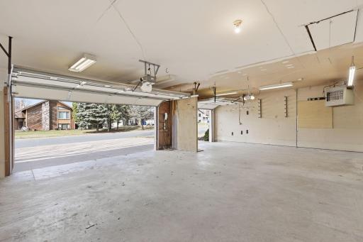 Clean, three-stall garage with ample storage space for vehicles, outdoor equipment and toys!