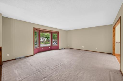 A large front window fills the spacious living room with natural light.