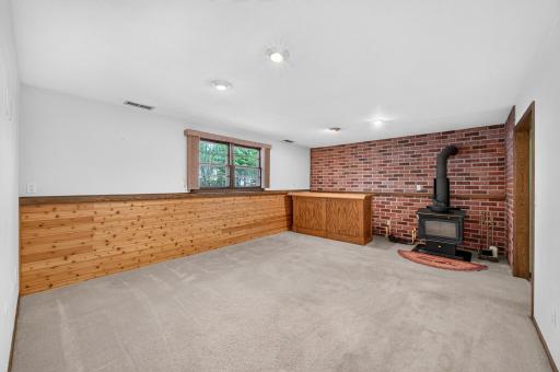 The finished walk-out lower level is ready for gatherings with a built-in bar and wood-burning stove.