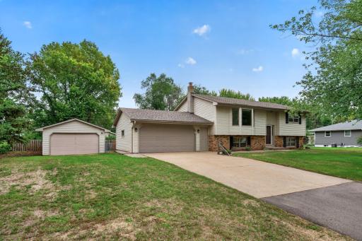An extended driveway leads to both the attached garage and the spacious detached garage.