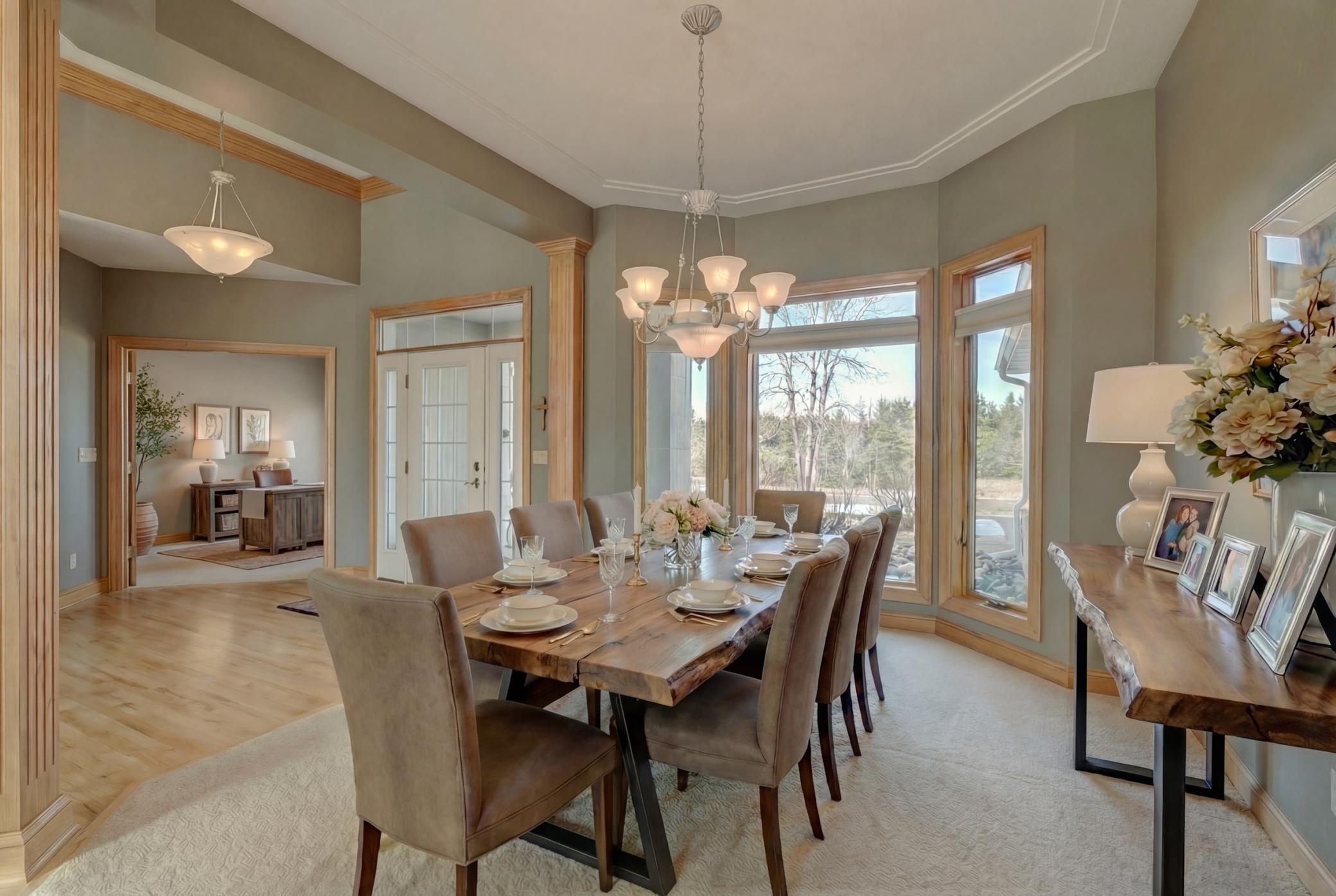 The dining area is enhanced by cove molding and rich 6-inch custom trim, adding warmth and character throughout, complemented by extensive custom cabinetry. (virtually staged)