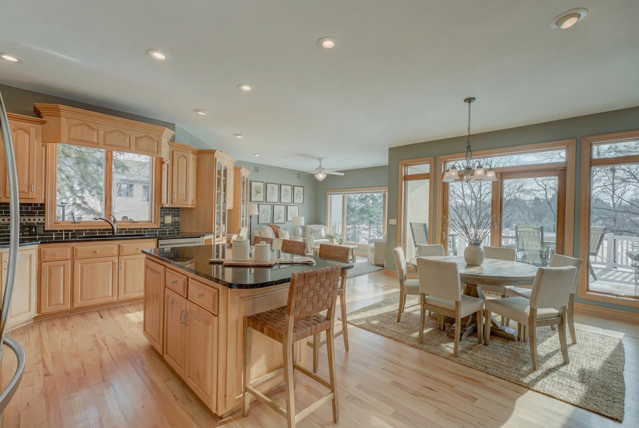 Off the beautifully designed kitchen, the light-filled sunroom provides a serene space to unwind, perfect for morning coffee with panoramic views or a quiet place to relax year-round. (virtually staged)