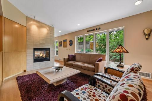 Expansive windows and a two-sided fireplace create a bright, inviting living room.