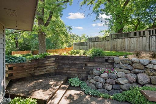 Stone retaining walls and mature plantings create a beautifully landscaped backyard retreat.