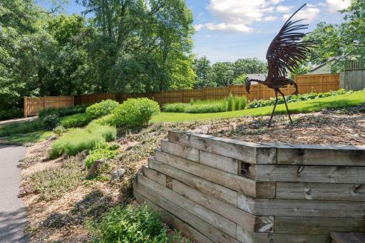 Mature trees and layered landscaping provide a lush, private backyard setting.