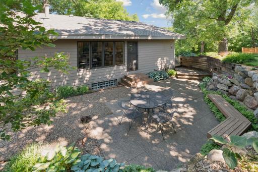 A spacious backyard patio offers a peaceful setting surrounded by mature landscaping.