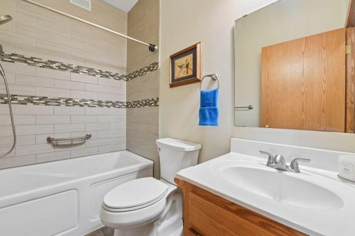 Updated full guest bathroom with soak tub/shower and tile surround.