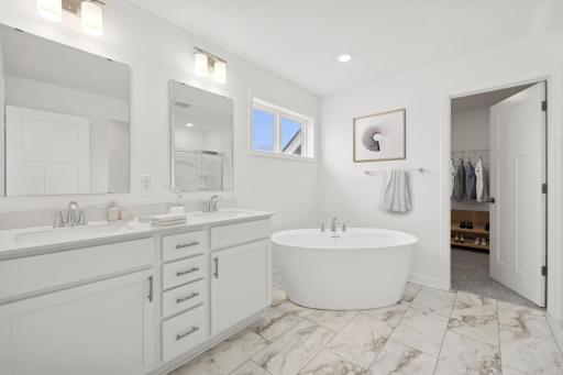 (Photo of similar home, finishes will vary) An extension of the primary bedroom, this private and spacious bath contains a double-vanity, a soaking tub and separate shower.