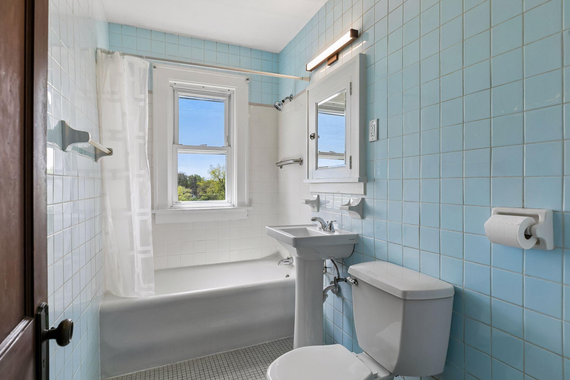 Upper level full bath with brand new pedestal sink and lighting.