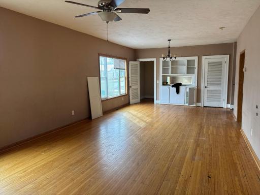 Main floor living room with dining room area on far end of photo