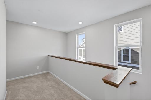 Upper level landing seperating primary suite from the other two bedrooms.