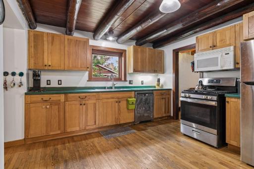 Spacious and open kitchen with more beautiful log ceiling.