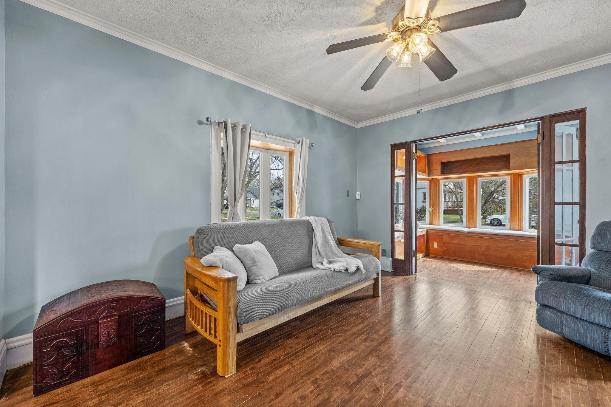 Spacious living room leads to the front sunroom with french doors and window seats. Gorgeous hardwood floors throughout home.