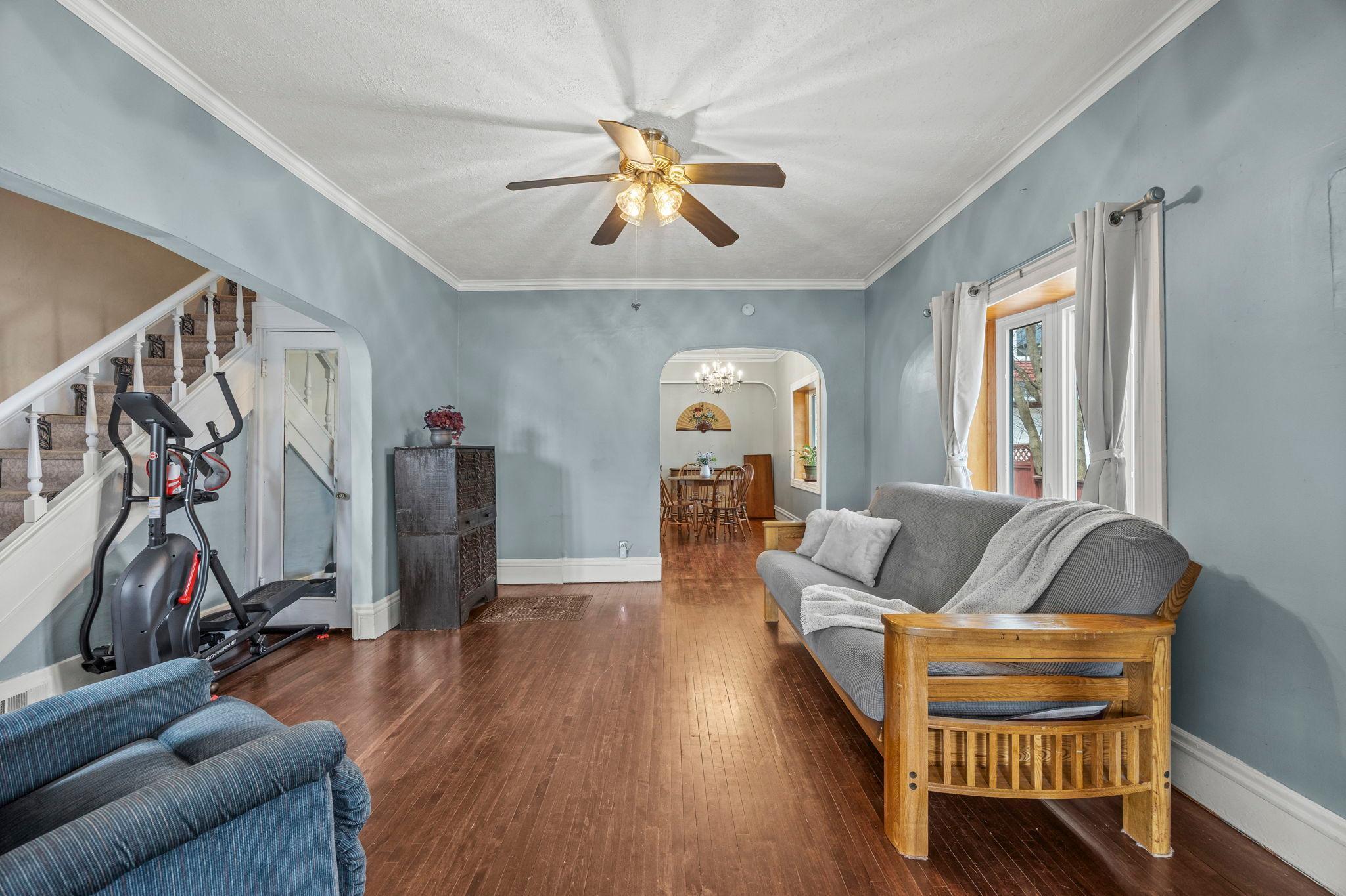 Living room has new bay window and beautiful hardwood floors. View of lovely open staircase on the left.