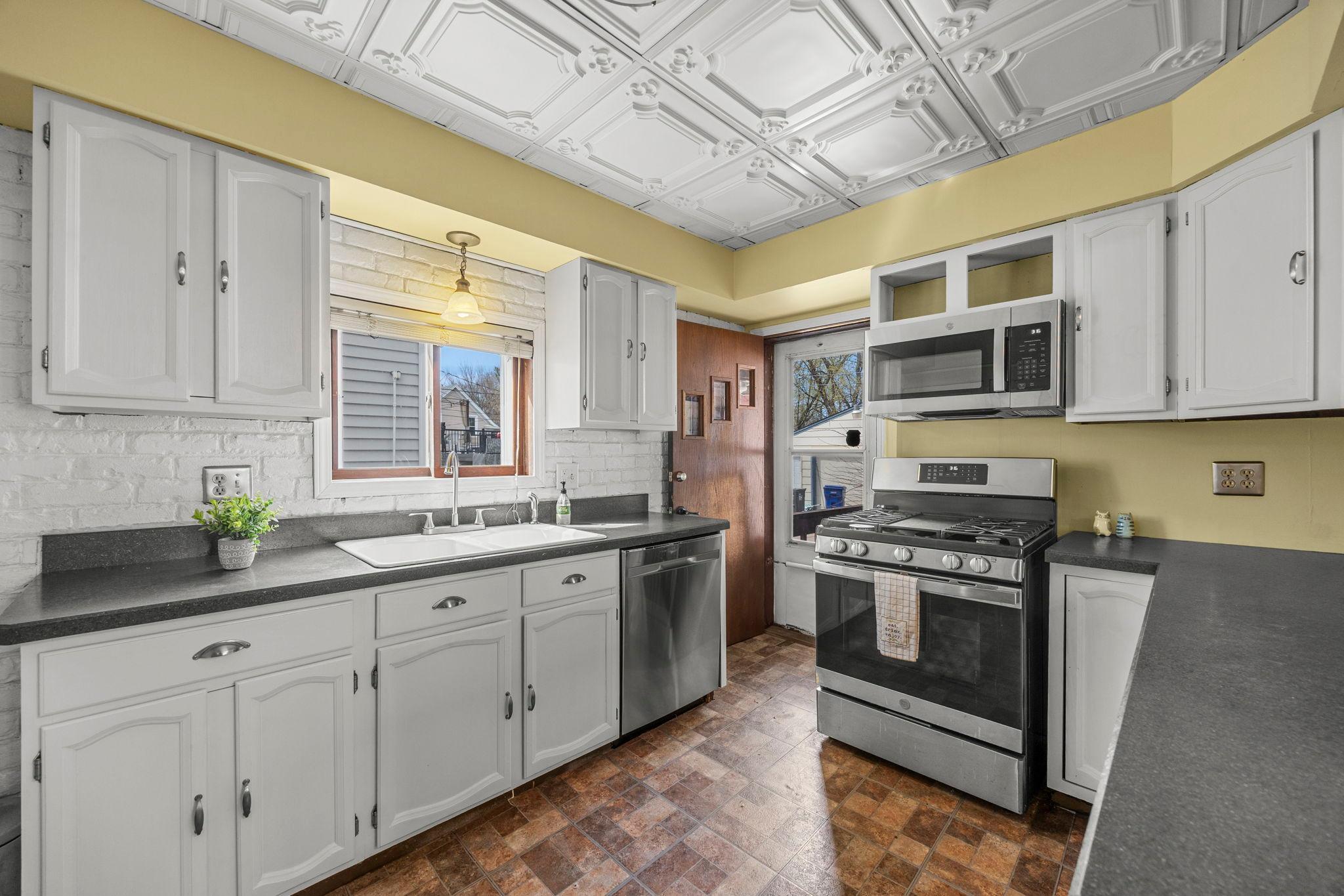 Freshly painted kitchen cabinets with brushed nickel hardware, kitchen window over double sink. You will love all the storage and newer SS appliances.