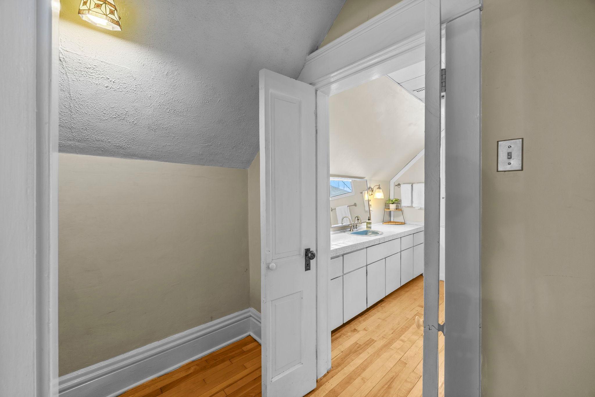 The full bath has a large vanity, tub/shower combo and hardwood floors.