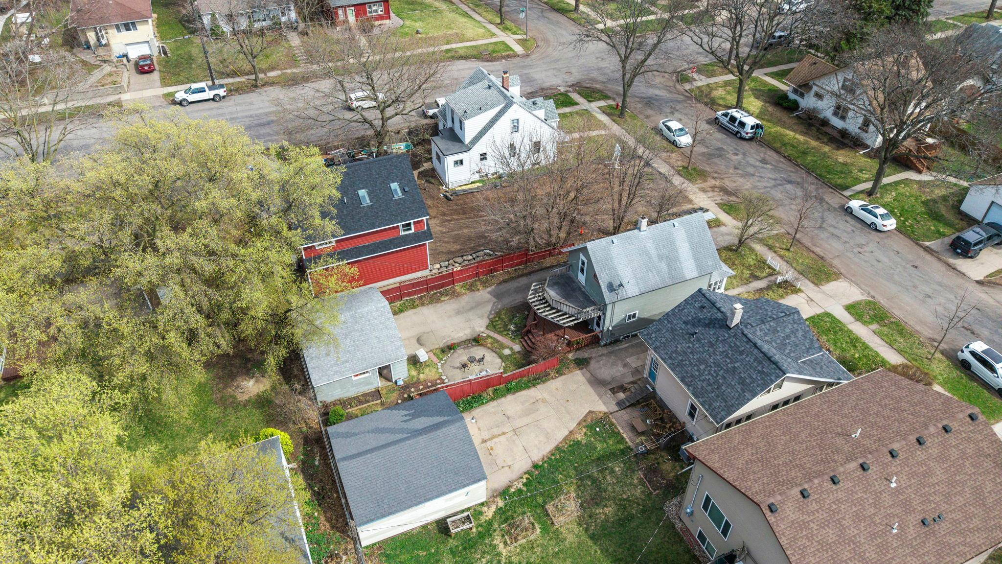 Aerial view of house, yard, decks, patio, yard/gardens and 2+ car garage.