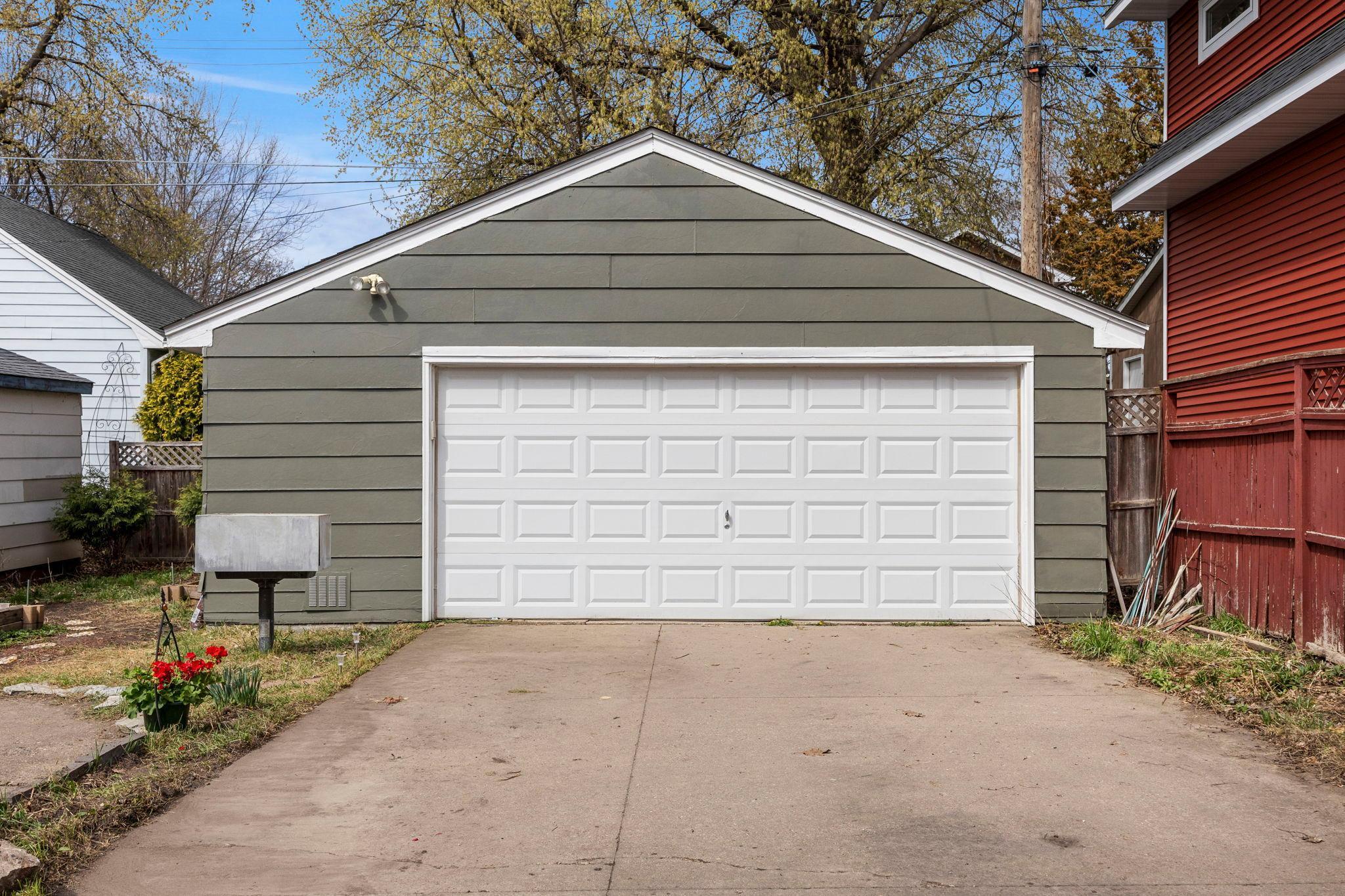 Big garage holds two cars plus has space for workshop or storage. Concrete driveway.