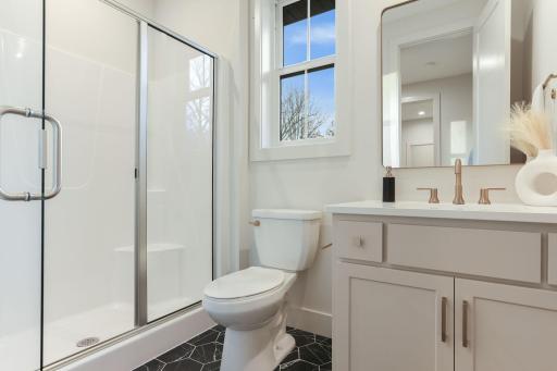 The main-level Â¾ bathroom combines modern design with practical elegance for guests or everyday use.