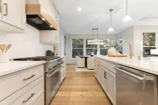 The kitchen features premium Thermador appliances, an oversized center island, custom soft-close cabinetry
