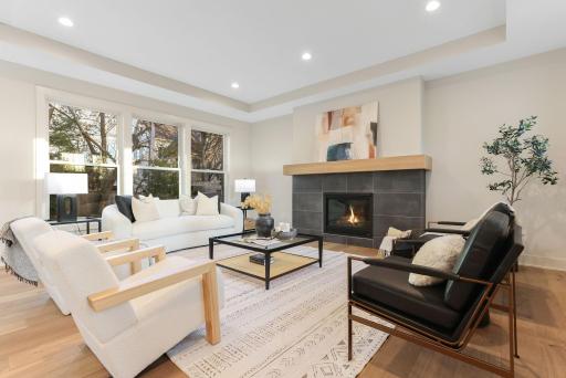 The open-concept main level is filled with natural light from Andersen windows and showcases elegant white oak hardwood floors, flowing seamlessly into the inviting Great Room anchored by a sophisticated gas fireplace.