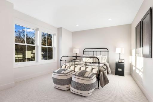 This spacious bedroom features a large walk-in closet and shares a stylish Jack and Jill full bathroom, complete with dual vanities and modern finishes.