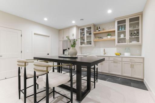The wet bar area in the lower level features quartz counters, a dishwasher and a full-size counter-depth refrigerator.